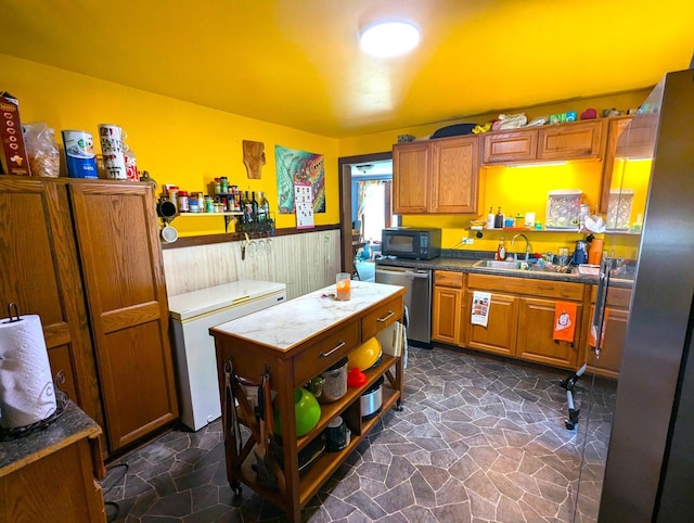 225 Caledonia St, La Crosse, WI 54603 - kitchen with appliances with stainless steel finishes, brown cabinets, dark stone finish floors, open shelves, and a center island