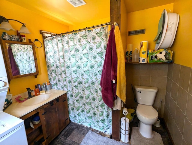225 Caledonia St, La Crosse, WI 54603 - bathroom with vanity, tile walls, a shower with shower curtain, and stone finish floors