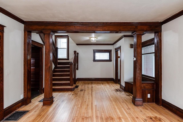 1140 Bluff St, Beloit, WI 53511 - foyer featuring light wood-style floors, plenty of natural light, crown molding, and ornate columns