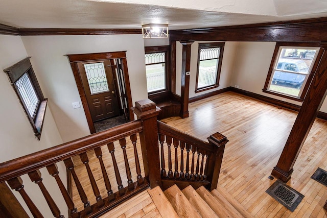 1140 Bluff St, Beloit, WI 53511 - entryway featuring light wood finished floors, ornamental molding, and stairway