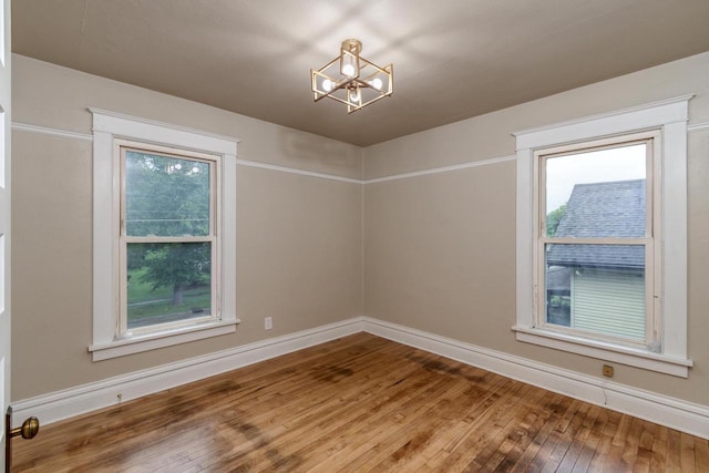 1140 Bluff St, Beloit, WI 53511 - spare room featuring wood-type flooring and a chandelier