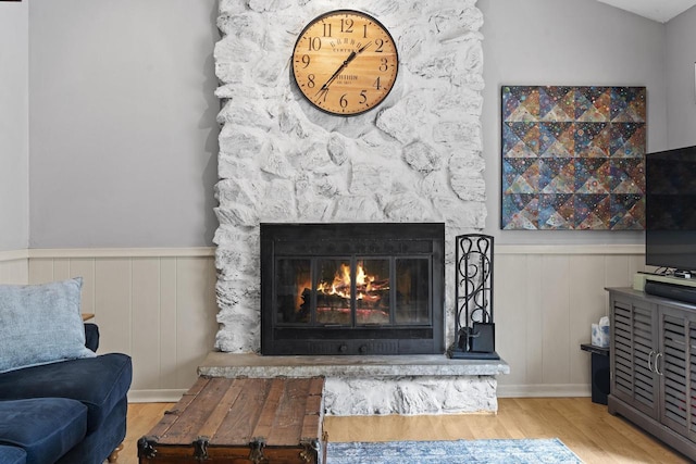 611 Mount Snowdon Rd, Wales, WI 53183 - detailed view of wood finished floors, a wainscoted wall, a stone fireplace, and a decorative wall