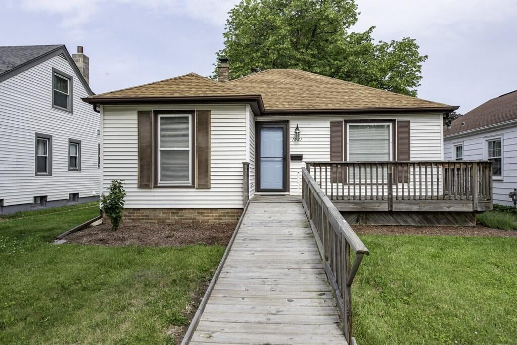 1521 Monroe Ave, Racine, WI 53405 - view of front facade featuring a front yard, a deck, roof with shingles, and a chimney