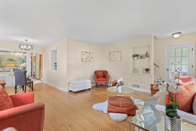 5463 N Lydell Ave, Glendale, WI 53217 - living room with wood finished floors, a chandelier, and healthy amount of natural light