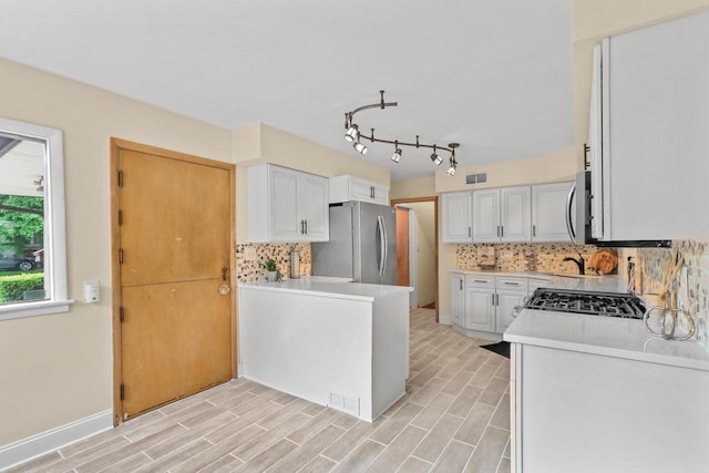 5463 N Lydell Ave, Glendale, WI 53217 - kitchen featuring appliances with stainless steel finishes, white cabinets, backsplash, and light wood-style flooring