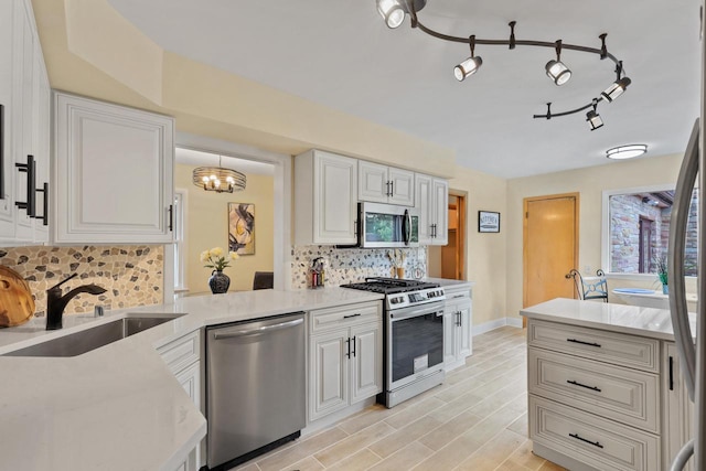 5463 N Lydell Ave, Glendale, WI 53217 - kitchen featuring appliances with stainless steel finishes, decorative backsplash, a chandelier, and white cabinetry