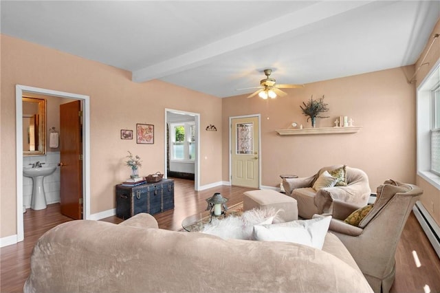 110 1st Ave, Balsam Lake, WI 54810 - living area with wood finished floors, beam ceiling, ceiling fan, a baseboard heating unit, and a baseboard radiator