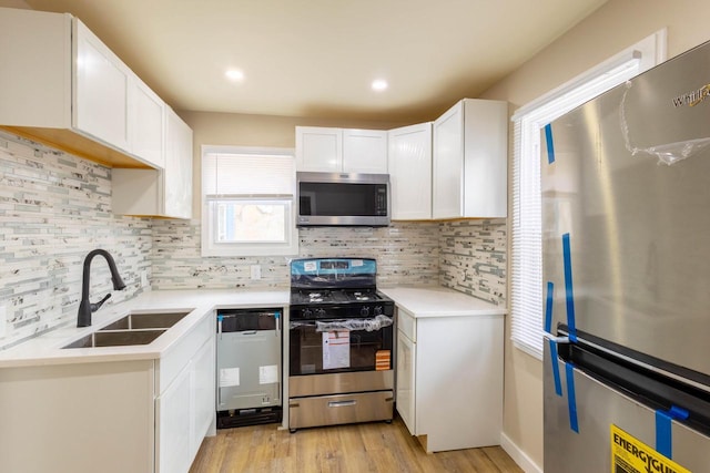 4366 N 25th St, Milwaukee, WI 53209 - kitchen featuring appliances with stainless steel finishes, decorative backsplash, white cabinetry, light wood-style floors, and recessed lighting