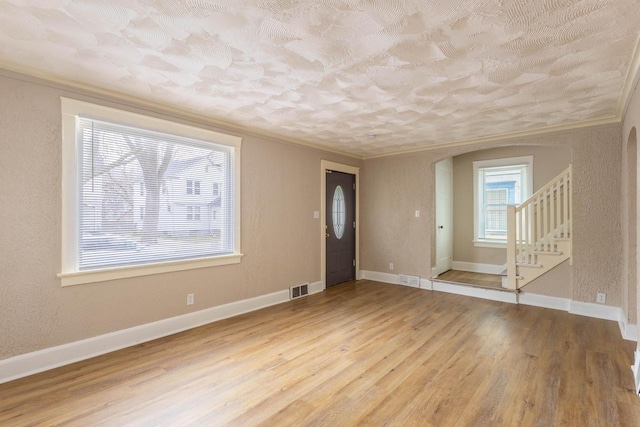 4366 N 25th St, Milwaukee, WI 53209 - entrance foyer with ornamental molding, wood finished floors, arched walkways, stairway, and a textured wall