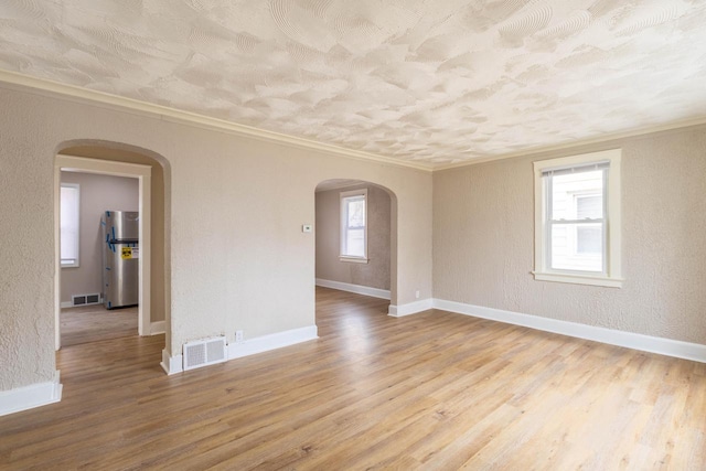 4366 N 25th St, Milwaukee, WI 53209 - empty room with arched walkways, crown molding, wood finished floors, and a textured wall