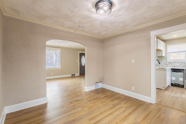 4366 N 25th St, Milwaukee, WI 53209 - empty room featuring arched walkways, light wood-type flooring, a textured wall, and crown molding