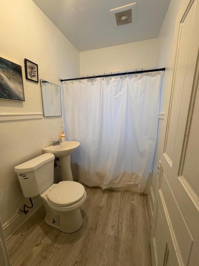 2341 S 12th St, Milwaukee, WI 53215 - bathroom featuring wood finished floors and a shower with shower curtain