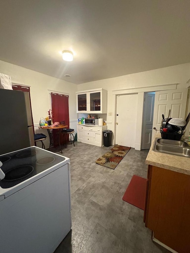 2341 S 12th St, Milwaukee, WI 53215 - kitchen with appliances with stainless steel finishes, white cabinetry, light countertops, and dark floors