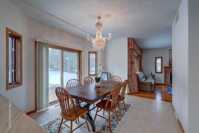 4205 Monarch Ct, Middleton, WI 53562 - dining area featuring a chandelier, light tile patterned floors, and a tiled fireplace