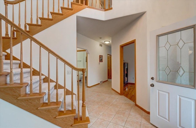 4205 Monarch Ct, Middleton, WI 53562 - foyer featuring light tile patterned floors, stairway, and arched walkways
