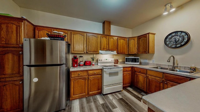 654 Riverview Ct Unit 2-Bldg C, Jefferson, WI 53549 - kitchen featuring freestanding refrigerator, white electric range oven, under cabinet range hood, brown cabinets, and wood finished floors