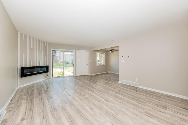 W169N11492 Biscayne Dr, Germantown, WI 53022 - unfurnished living room featuring light wood-type flooring, a ceiling fan, and a glass covered fireplace