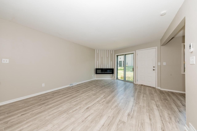 W169N11492 Biscayne Dr, Germantown, WI 53022 - unfurnished living room with light wood-type flooring and a glass covered fireplace