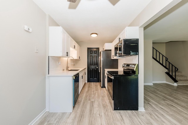 W169N11492 Biscayne Dr, Germantown, WI 53022 - kitchen with appliances with stainless steel finishes, light countertops, white cabinets, and light wood finished floors