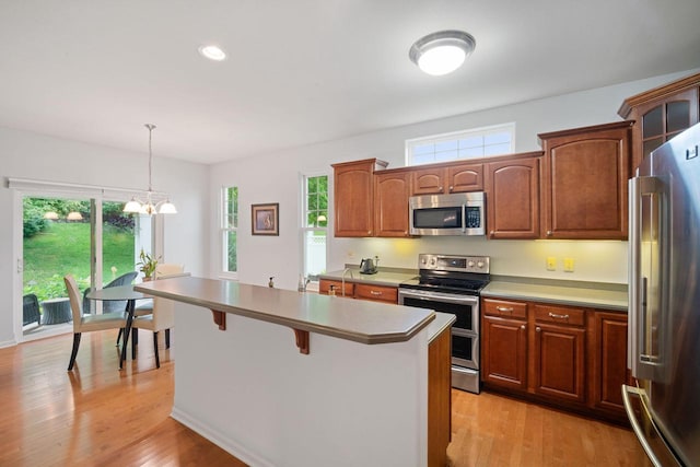 N52W35297 Lighthouse Ln, Oconomowoc, WI 53066 - kitchen with stainless steel appliances, plenty of natural light, a kitchen bar, a center island, and recessed lighting