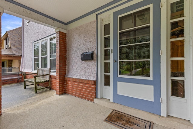 4069 N Prospect Ave, Shorewood, WI 53211 - entrance to property featuring a porch, brick siding, and stucco siding