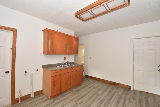 1600 Winslow St, Racine, WI 53404 - kitchen with light wood-type flooring, brown cabinets, a textured ceiling, and dark countertops