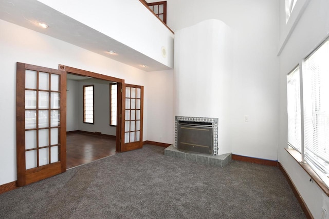 1600 Winslow St, Racine, WI 53404 - unfurnished living room featuring carpet floors, french doors, a tile fireplace, and a towering ceiling