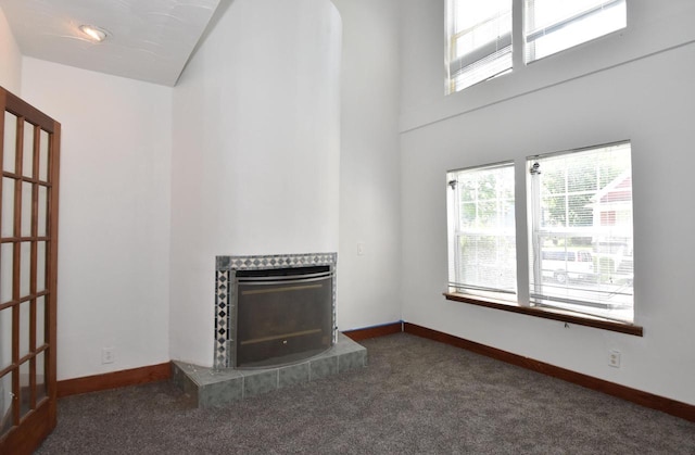1600 Winslow St, Racine, WI 53404 - unfurnished living room featuring healthy amount of natural light, carpet flooring, a tile fireplace, and a high ceiling