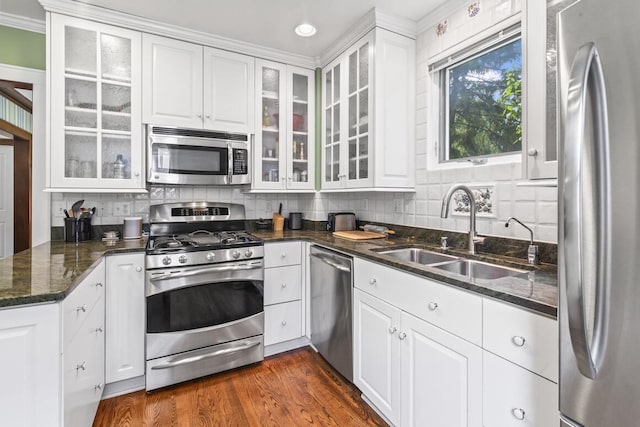 1853 N 83rd St, Wauwatosa, WI 53213 - kitchen with stainless steel appliances, white cabinets, decorative backsplash, dark stone counters, and dark wood-type flooring