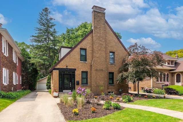 1853 N 83rd St, Wauwatosa, WI 53213 - tudor house with an outdoor structure, brick siding, a chimney, and a detached garage