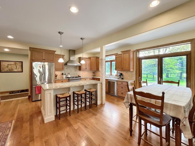 2307 W Willow Creek Ln, Sheboygan, WI 53083 - kitchen featuring stainless steel appliances, wall chimney exhaust hood, a kitchen island, decorative backsplash, and recessed lighting