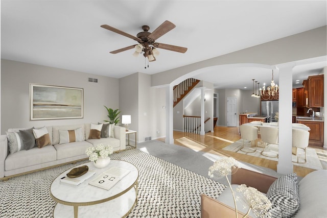 4227 Savannah Ct, Middleton, WI 53562 - living area featuring arched walkways, a ceiling fan, stairway, and a chandelier