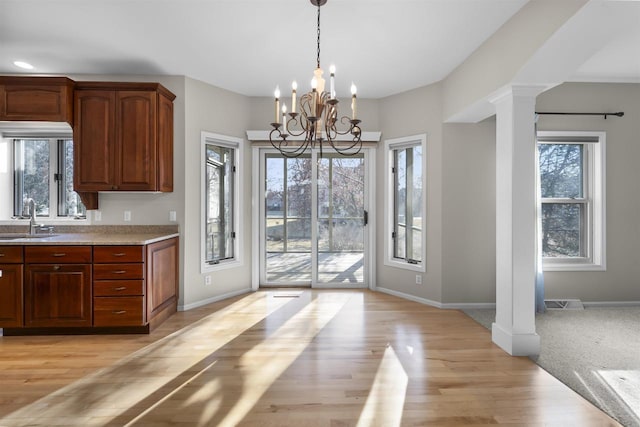 4227 Savannah Ct, Middleton, WI 53562 - kitchen featuring ornate columns, light countertops, plenty of natural light, and light wood-type flooring