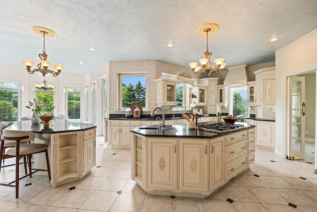 1626 Fox Hollow Ln, Cedarburg, WI 53012 - kitchen with cream cabinets, open shelves, a chandelier, a center island with sink, and stainless steel gas cooktop