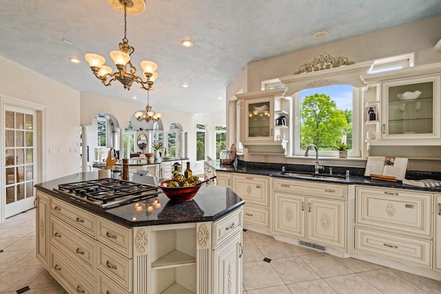 1626 Fox Hollow Ln, Cedarburg, WI 53012 - kitchen with cream cabinets, stainless steel gas cooktop, open shelves, a chandelier, and healthy amount of natural light