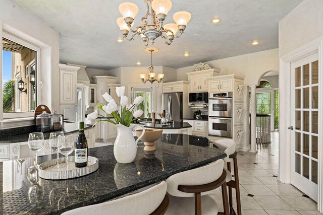 1626 Fox Hollow Ln, Cedarburg, WI 53012 - dining space with a chandelier, plenty of natural light, light tile patterned floors, arched walkways, and recessed lighting