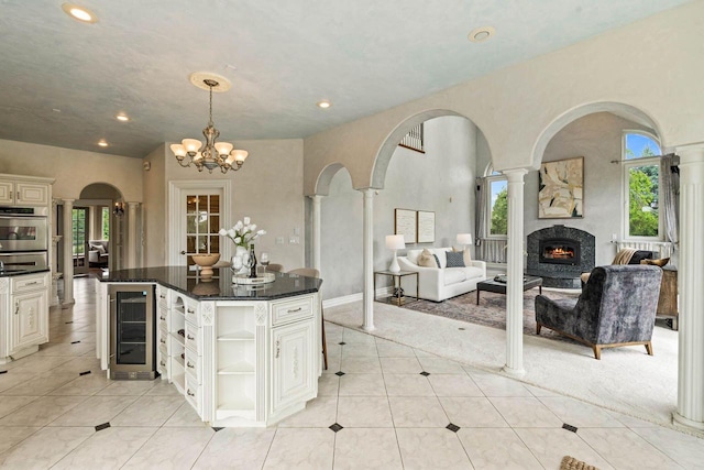 1626 Fox Hollow Ln, Cedarburg, WI 53012 - kitchen with beverage cooler, ornate columns, open floor plan, arched walkways, and recessed lighting