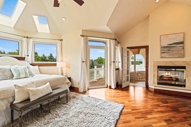 1626 Fox Hollow Ln, Cedarburg, WI 53012 - bedroom featuring access to exterior, multiple windows, high vaulted ceiling, wood finished floors, and a skylight