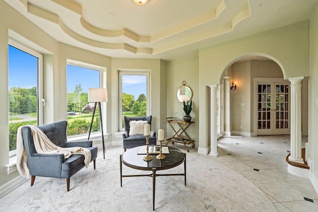 1626 Fox Hollow Ln, Cedarburg, WI 53012 - sitting room with ornate columns, arched walkways, a tray ceiling, and tile patterned floors