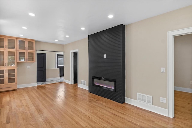 3009 N 72nd St, Milwaukee, WI 53210 - unfurnished living room featuring light wood-style floors, a fireplace, and recessed lighting