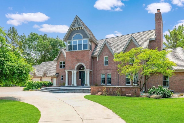 N69W29753 Ridgeview Ct, Hartland, WI 53029 - view of front of property featuring brick siding, a chimney, and a front lawn
