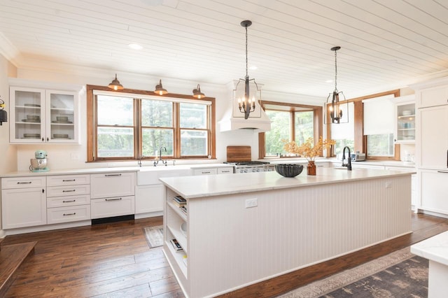 N69W29753 Ridgeview Ct, Hartland, WI 53029 - kitchen with white cabinets, crown molding, a kitchen island with sink, wood ceiling, and hanging light fixtures