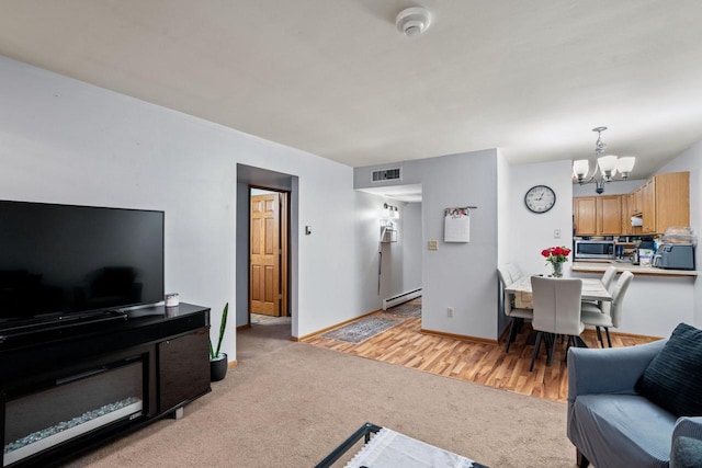 4050 W Rivers Edge Cir Unit 25, Brown Deer, WI 53209 - living room featuring baseboard heating, a chandelier, and light carpet