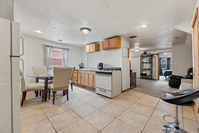 3946 N 25th St, Milwaukee, WI 53206 - kitchen with white appliances, light tile patterned floors, a textured ceiling, light carpet, and recessed lighting