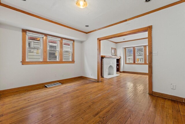 3946 N 25th St, Milwaukee, WI 53206 - unfurnished living room featuring ornamental molding, a fireplace, and hardwood / wood-style floors