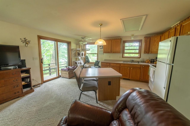 N5642 8th Dr, Westfield, WI 53964 - kitchen featuring freestanding refrigerator, light countertops, brown cabinetry, range, and light carpet