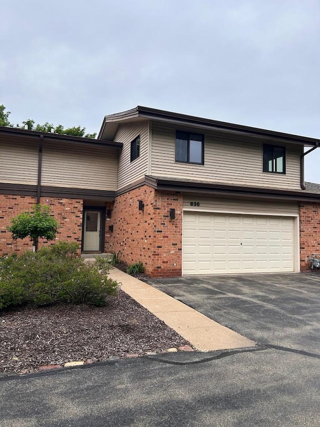 836 Pilgrim Pkwy, Elm Grove, WI 53122 - view of front of home with a garage, brick siding, and driveway