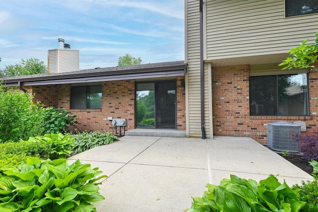 836 Pilgrim Pkwy, Elm Grove, WI 53122 - doorway to property featuring brick siding, a patio, and a chimney