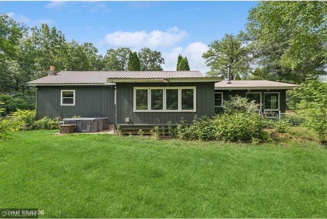 2818 Wilson Ave, Saint Croix Falls, WI 54024 - rear view of house with a lawn, a metal roof, and a chimney