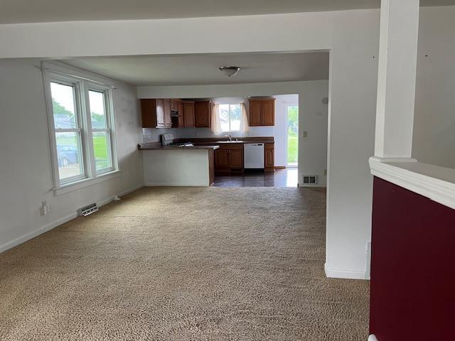 1153 W 7th Ave, Oshkosh, WI 54902 - kitchen featuring dishwasher, dark colored carpet, range, open floor plan, and a peninsula